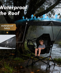 Child sitting in Portable Folding Hammock Camping Chair With Canopy And Footrest under rain by tree, showing waterproof fabric.