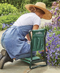Person using Do It All Garden Kneeler Seat With Padded Cushion And Detachable Tool Bag, Versatile Foldable Garden Stool for comfort weeding.