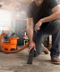 Heavy Duty Wet Dry Vacuum And Blower With 12 Gallon Capacity And 5 Peak Horsepower Detachable Leaf Blower Head For Workshop Cleanup in use on garage floor.