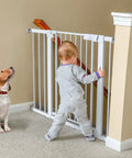Child and dog behind Extra Wide Baby Gate For Stairs And Doorways 27 To 43 Inches Auto Close Safety Gate With Extenders Pressure Or Hardware Mount Kit Easy Install 30 Inch Tall White