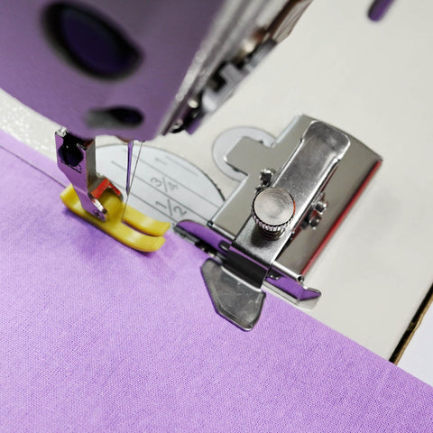 Magnetic seam guide sewing machine accessory on purple presser foot guiding purple fabric