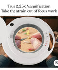 Close-up view of LightView Pro Magnifying Floor Lamp with Stand focusing on detailed craft work through 5D glass magnifier lens.