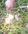 Hands using Extra Large Half Inch By Six Inch Ferro Rod Survival Fire Starter Ferrocerium with lanyard hole, sparks on grass