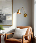 Ellis 18 Inch Two Pack Modern Gold Swing Arm Wall Sconces With Cone Shades Adjustable Heads in living room with armchair