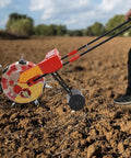 Person using Hand Push Garden Seeder With Seven Nozzles For Precision Row Planting in field, adjustable depth and spacing.