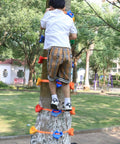 Child using Kids Outdoor Ninja Climbing Holds Set With 18 Rock Grips And 6 Ratchet Straps on a backyard tree.