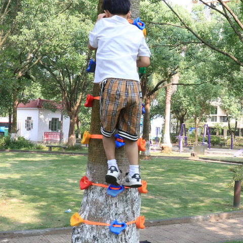 Child using Kids Outdoor Ninja Climbing Holds Set With 18 Rock Grips And 6 Ratchet Straps on a backyard tree.