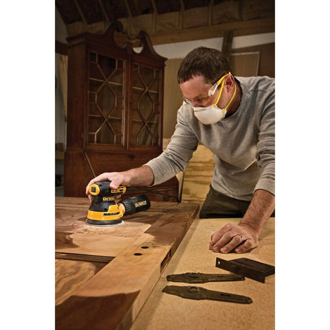 Man using Compact 5 Inch Variable Speed Orbital Sander Kit With 3 Amp Motor Reducing Vibration For Comfort And Close Reach on wood