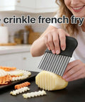 French fry slicer with stainless steel blade and black handle; cuts potatoes into crinkle fries.