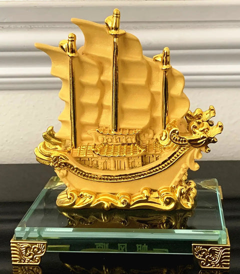 Gold Dragon Feng Shui Sailing Ship Statue For Home And Office Decor Boosts Fortune, Success, And Prosperity Dope Gift For Housewarmings, Graduations, Birthdays, And Special Occasions displayed on a glass base.