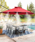 Outdoor patio with red umbrella misting, showcasing 10 Pack Solid Brass Misting Nozzles For Outdoor Cooling System Replacement Nozzles For One Quarter Inch Tubing Patio Backyard Garden Greenhouse Mister Accessories Create Fine Mist With 20 To 40 Inch Coverage Up To 20 Degrees Cooler over dining area by pool.