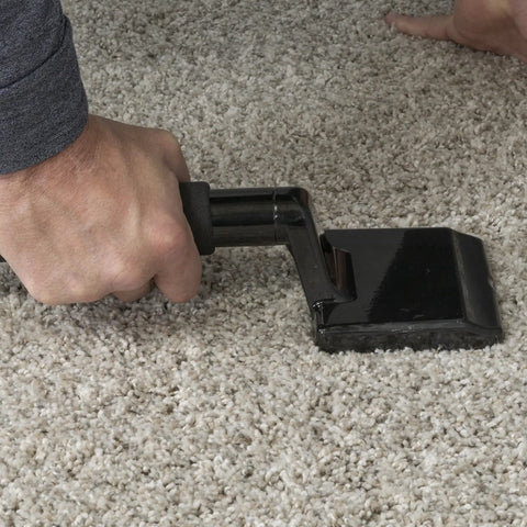 Hand using Budget Carpet Knee Kicker For Quick Install And Positioning With Angled Teeth Grip Non Adjustable Economy Tool on carpet