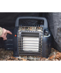 Hunting Buddy Space Heater 6K To 12K BTU Outdoor Heater used in a camping setup, featuring camouflage finish and auto shutoff.