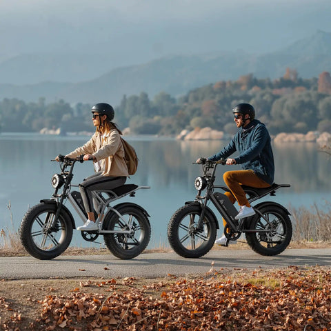 Two adults riding Powerful 1500W Peak Fat Tire Electric Bike For Adults With 20X4 Inch All Terrain Tires along a lakeside path.