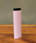 Reusable Skin File With Cover For Rock Climbing And Bouldering, pink textured surface with black cover, standing on a table.