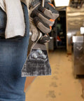 Worker holding 5 In. By 11 In. SDS-Plus Bulldog Floor Scraper With Durable Steel Blade, Locking Bolt Attachment