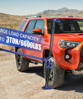 6600 Lb Heavy Duty Farm Jack With 60 Inch High Lift for a red SUV on rough terrain, demonstrating large load capacity.