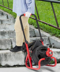 Heavy Duty Workhorse Electric Drain Auger Machine With Automatic Forward And Reverse Footswitch Control Plug And Play Badass Performance For Pro Plumbers One Hundred Feet By Three Eighths Inch Steel Cable navigated by a person down stone stairs.