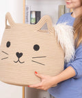 Person holding a Large Cotton Rope Storage Basket with Cozy Cat Face Design for Towels, Blankets, Toys, 15 by 14 inches.