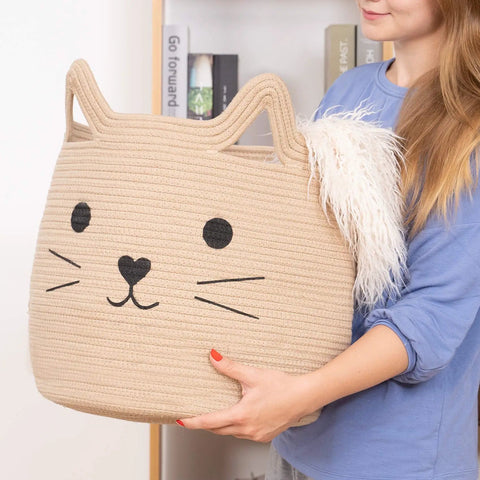 Person holding a Large Cotton Rope Storage Basket with Cozy Cat Face Design for Towels, Blankets, Toys, 15 by 14 inches.