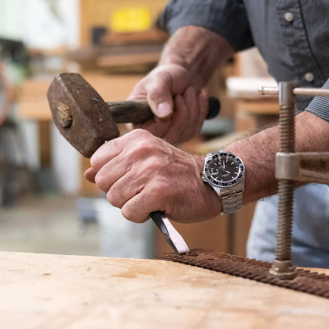 Person using a 16 Piece Punch And Chisel Set With Pin Punches And Center Punches For Metalwork, Auto Repair And DIY Projects on a workbench