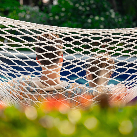 Two Person 12 Ft Double Rope Hammock With Spreader Bar Hand Woven Cotton Outdoor Patio Hammock For Poolside Lounging Fits 13 To 15 Ft Stand Supports Up To 450 Lbs Natural Color 141 X 57 Inches with two people relaxing in it.