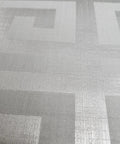 Close-up of Modern Geometric Greek Key Wallpaper With Metallic Matte Finish, showcasing textured gray silver pattern.