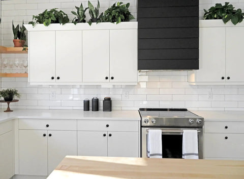 Modern kitchen with white cabinets equipped with 30 Pack Matte Black Zinc Euro Style Cabinet Knobs Set One And One Quarter Inch Drawer Pulls.
