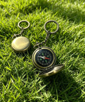 Pocket compass on grass, part of Custom Damascus Steel Folding Knife With Wooden Handle And Separate Compass In Wooden Gift Box.