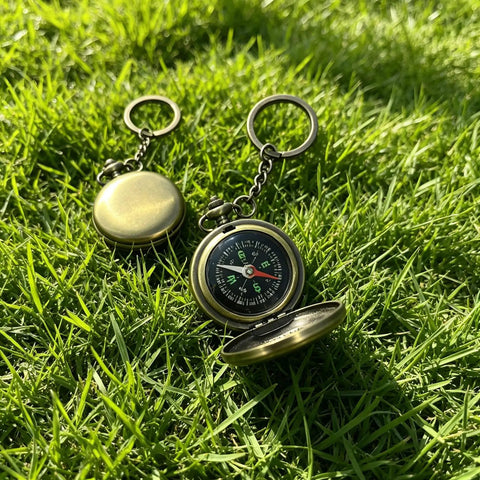 Pocket compass on grass, part of Custom Damascus Steel Folding Knife With Wooden Handle And Separate Compass In Wooden Gift Box.