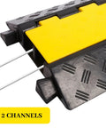 Close-up of a Two Channel Rubber Cable Ramp Protector and Cord Cover showing black and yellow channels with cables passing through.