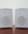 Five Point Twenty Five Inch Three Way Outdoor Indoor Wired Speakers with Weather Resistant Build displayed on wooden surface