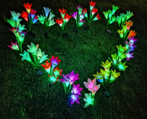 Heart-shaped display of Solar Garden Stake Lights 8 Pack With 32 Lily Flowers Waterproof 7 Color Changing LED Landscape Lights