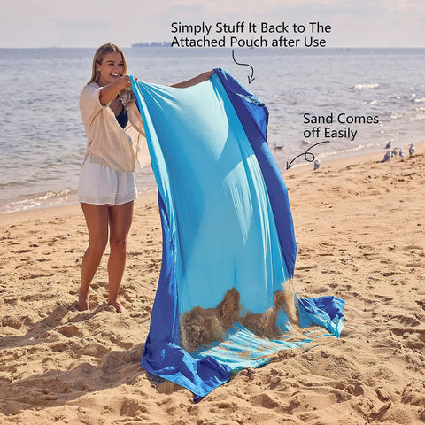 Woman shaking sand off Sandproof Beach Blanket With 6 Stakes And 4 Corner Pockets Large 7 By 7 Feet 210 Cm Square Quick Dry
