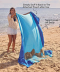 Woman shaking Oversized Sandproof Beach Blanket 10x9 For 2 To 8 Adults, Big Yet Lightweight Quick Dry Mat at the beach