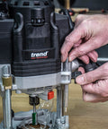 Hands adjusting the Beefy Dual-Mode Plunge Router 3-1/4 HP with 1/2 Inch Collet, Variable Speed, Router Table Ready on a workbench.