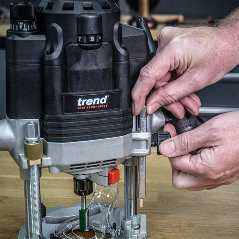 Hands adjusting the Beefy Dual-Mode Plunge Router 3-1/4 HP with 1/2 Inch Collet, Variable Speed, Router Table Ready on a workbench.