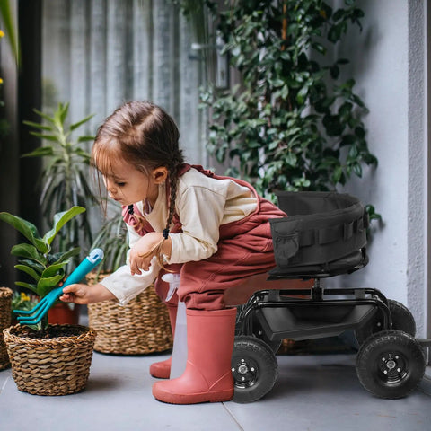 Child using a Rolling Garden Stool With Seat And Extendable Handle Tool Cart With Wheels And Extra Storage Knee Friendly Seat For Planting And Weeding Durable Steel Frame In Black next to potted plants.