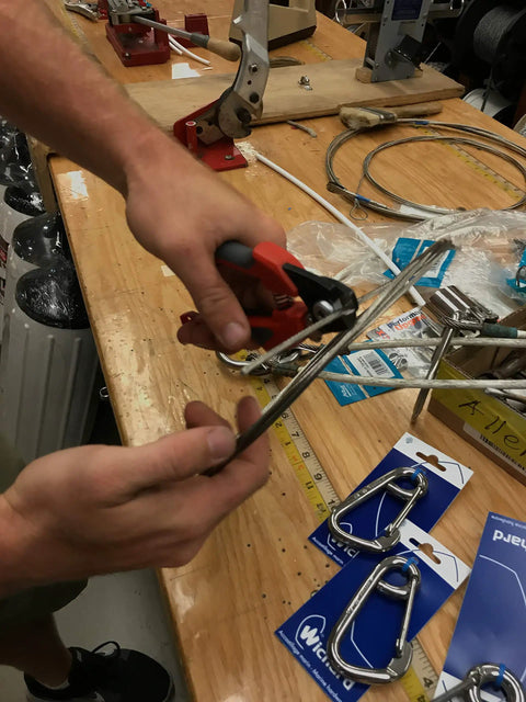 Person using 7 Inch Wire Rope Cutter For Railing And Cable Installations With Induction Hardened Blades on a steel cable