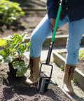 Person using Bulb Planter And All In One Lawn Plugger Tool With Long Handle Serrated Base for flower planting in garden