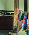 Person using power sander on wood with 12V Max Lithium Ion Battery 2Ah Pack Two Battery Pack For Power Tools, Lightweight And Compact.