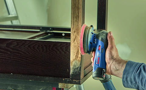 Person using a power tool with 12 Volt Max Lithium Ion 2.0Ah High Capacity Battery For Power Tools on wooden furniture piece.