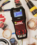 Commercial Heavy Duty Industrial Label Maker Kit Printing On Wide Heat Shrink Vinyl And Self Laminating Tape, displayed with tools and labels.