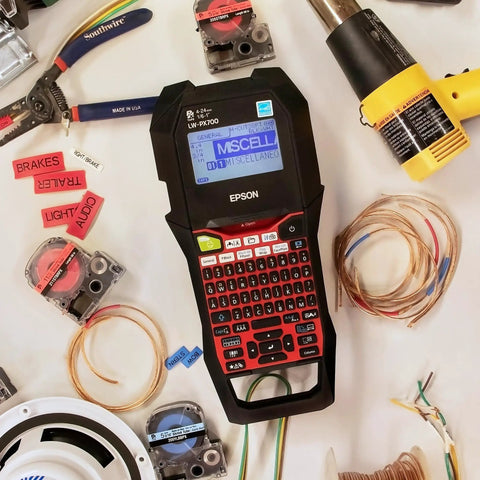 Commercial Heavy Duty Industrial Label Maker Kit Printing On Wide Heat Shrink Vinyl And Self Laminating Tape, displayed with tools and labels.