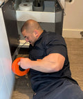 Man using Pro 50 Foot Heavy Duty Steel Drum Drain Auger Plumbing Snake With Work Gloves And Storage Bag for clog removal