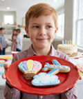 Boy holding cookies shaped like a hot air balloon, cloud, and airplane from the Adventure Travel Cookie Cutter Set, 3-Piece Made in USA