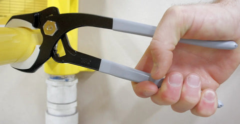 Wide Opening Pipe Pliers With Soft Jaw And Interchangeable Round And Square Jaws, 14 Inch Length, held gripping a yellow pipe