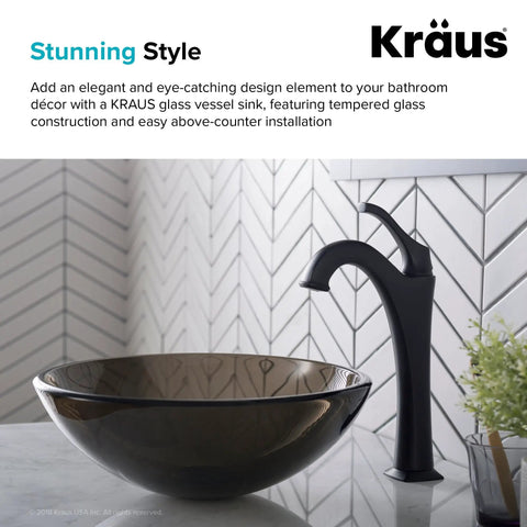 Slick Round Clear Brown Glass Vessel Sink, 14 Inch Above-Counter Bathroom Vanity Basin next to a wall-mount faucet on a countertop.