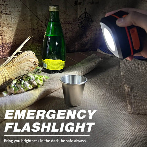 Hand holding Two Pack Folding Solar Lantern Flashlights Kit Mini Collapsible USB Rechargeable Waterproof Hanging Lights shining on items.