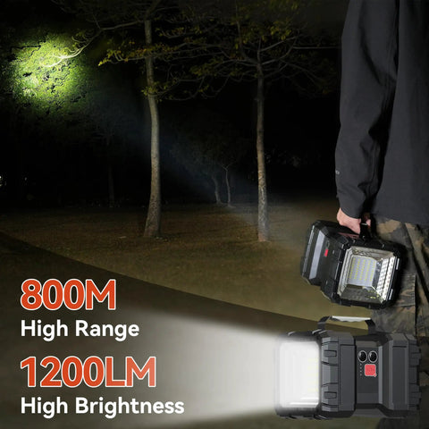 Person holding Ultra Bright Rechargeable LED Spotlight Flashlight With 1200 Lumens, 800 Meter Range, illuminating trees at night.